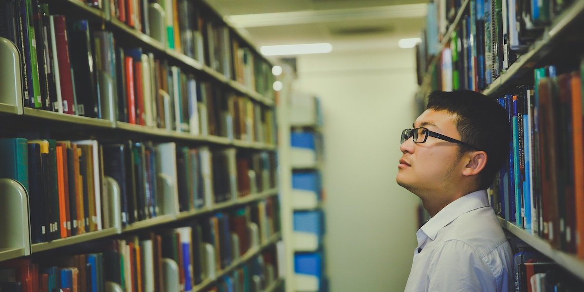 Student looking at bookshelf